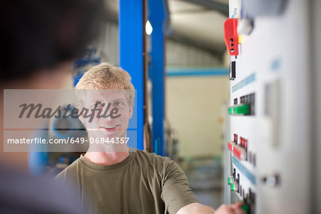 Man at control panel in olive processing plant