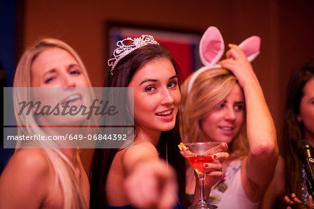 Young woman wearing tiara holding cocktail