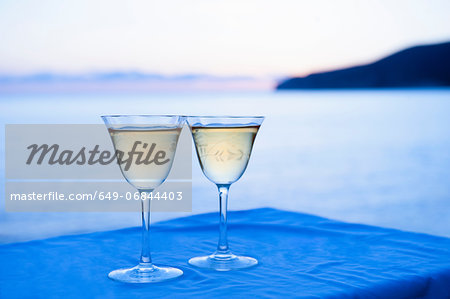 Two wine glasses with sea in background