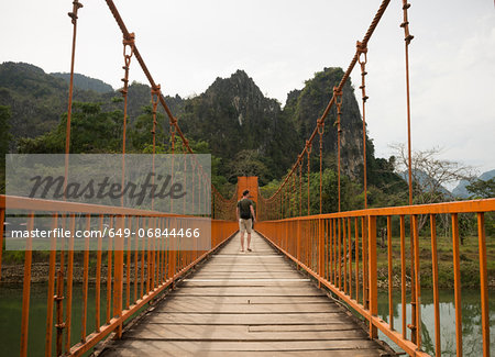Man on bridge over river, Vang Vieng, Laos