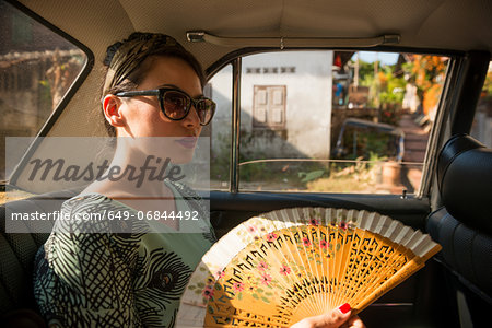 Woman in taxi holding fan