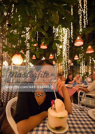 Woman drinking exotic drink in outdoor restaurant