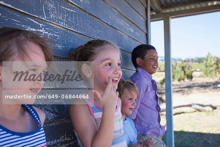 Four children outside clapboard cabin