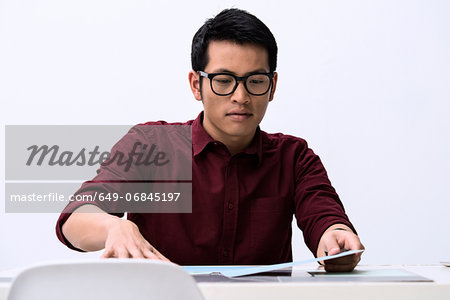 Young male designer looking at samples on desk