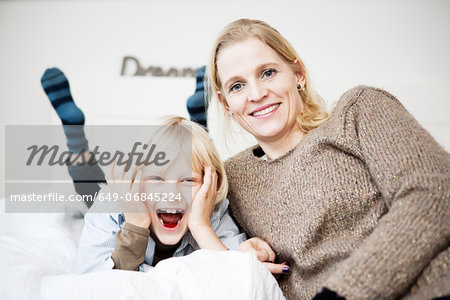 Fun portrait of mother and son on bed
