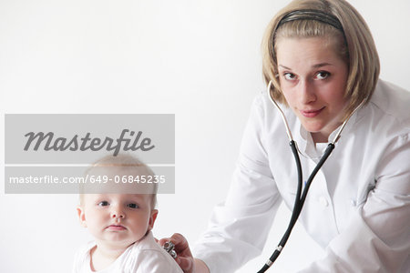 Female doctor examining baby's breathing