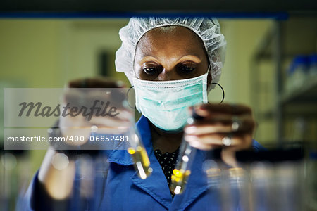 Science and research, woman working as chemist looking at test tube in laboratory