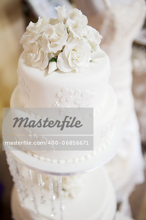 White layered wedding cake with roses, selective focus on roses