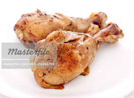 two crispy fried chicken legs on a white dish