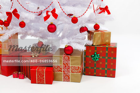 Close view of presents under white Christmas tree