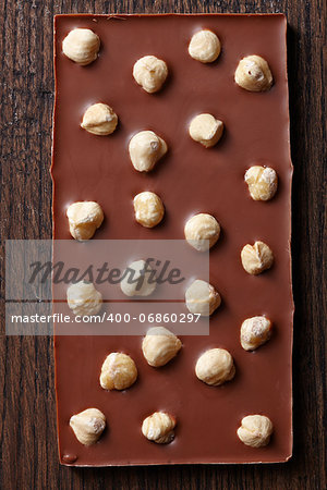 milk chocolate with hazelnuts on brown wooden table