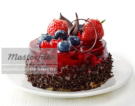 cake with fresh berries and chocolate on white plate