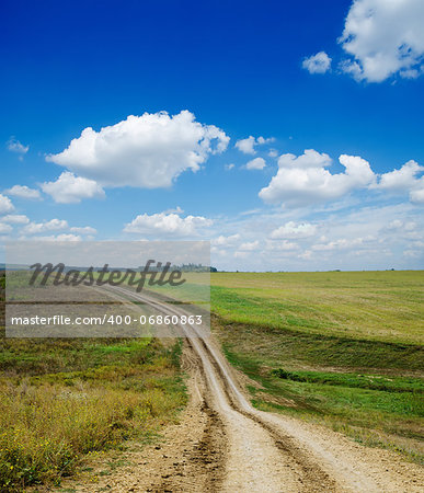 winding rural road under deep blue cloudy sky