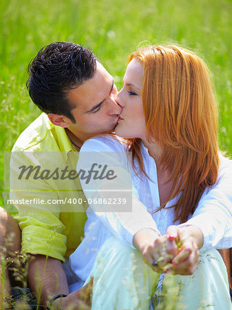 Young couplein their 20s kissing outdoor in summer.