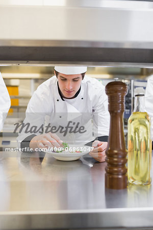 Chef finishing his salad in the kitchen