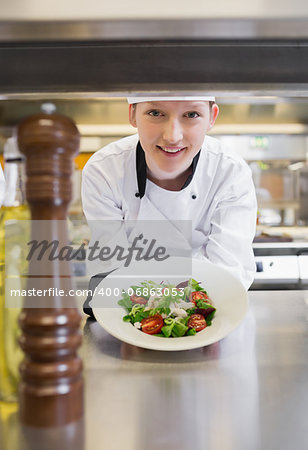 Chef happily presenting salad in kitchen