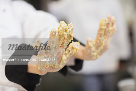 Chef's hands covered in dough