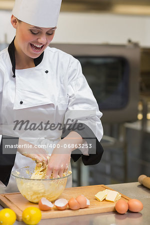 Smiling pastry chef mixing dough in kitchen