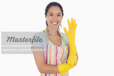 Smiling woman in apron pulling on rubber glove