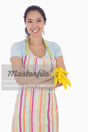 Woman smiling while holding rubber gloves and wearing an apron