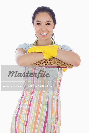 Smiling woman wearing gloves and apron leaning on mop