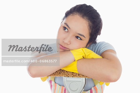 Troubled woman leaning on a mop in her apron