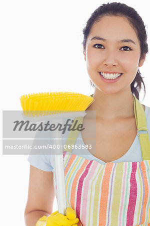 Smiling woman in apron with broom