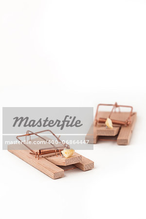 Two mousetraps with cheese on white background