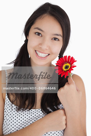 Happy woman holding a red daisy in polka dot dress