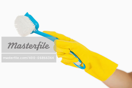 Female hand in rubber gloves holding blue scrubbing brush