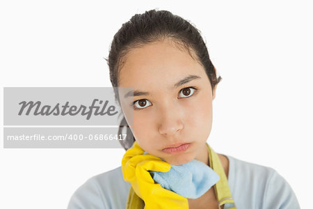Weary woman holding cleaning rag in apron and rubber gloves