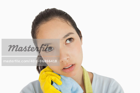 Tired woman wearing rubber gloves clutching cleaning rag