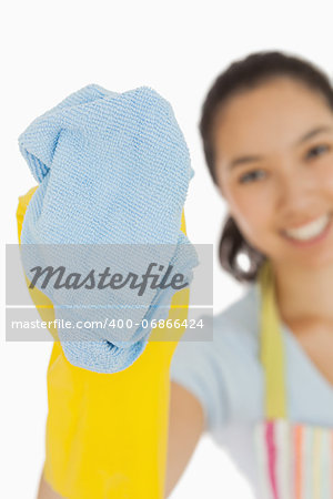 Laughing woman cleaning with cloth wearing rubber gloves and apron