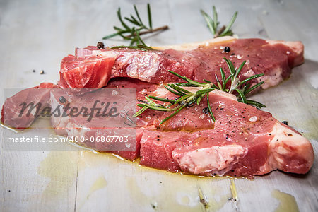 two fresh and raw beef steak seasoning with olive oil and herbs
