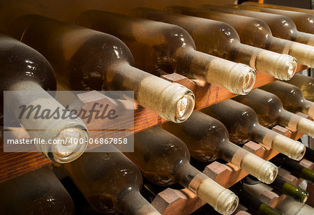 Wine bottles on shelf. Wine cellar. Close up wine bottles.