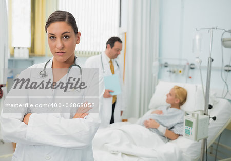 Female doctor folding her arms in a hospital room