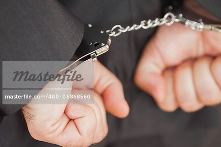 Closeup of hands in handcuffs clenching fists