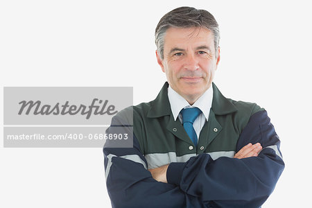 Portrait of confident electrician with arms crossed against white background