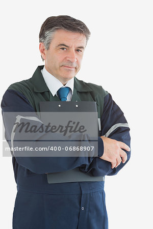 Portrait of confident repairman with clipboard over white background