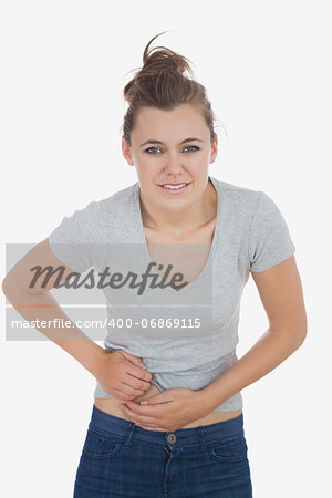 Portrait of beautiful woman suffering from stomachache over white background