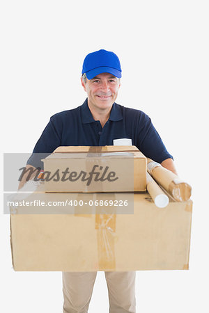 Portrait of happy courier man carrying cardboard packages over white background