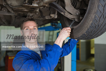 Portrait of male mechanic repairing car with spanner