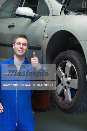 Portrait of car mechanic gesturing thumbs up in workshop