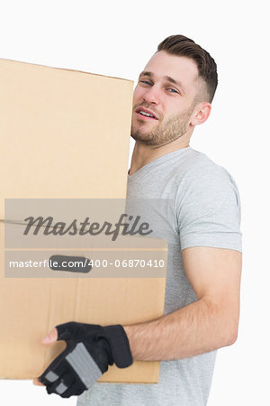 Portrait of tired young man carrying package boxes over white background