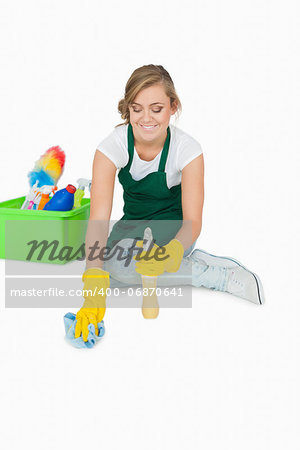 Young maid cleaning floor over white background