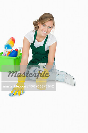 Portrait of young maid cleaning floor over white background