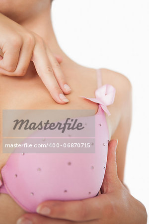 Extreme closeup of woman performing self breast examination over white background