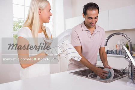 Happy couple washing dishes together