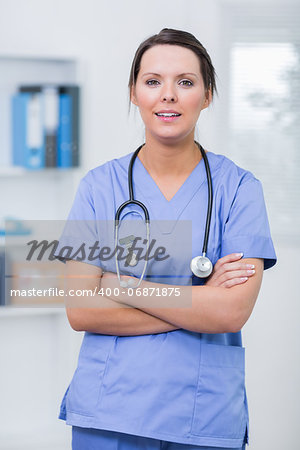 Portrait of confident young female surgeon with arms crossed at clinic