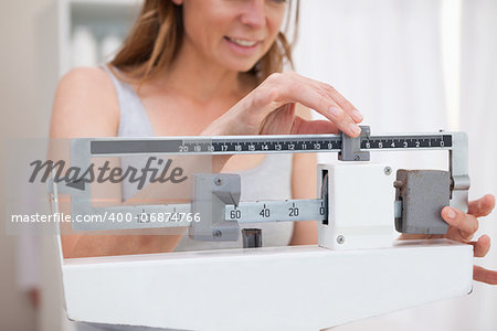 Woman adjusting medical scale